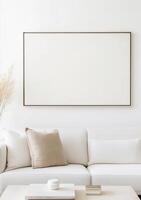 Minimalist living room featuring a white sofa, blank canvas wall art, and neutral decor photo