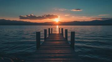 wooden pier extending over calm lake at sunset with reflection photo