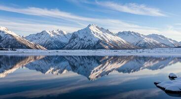 Snow covered mountains reflected in a lake photo