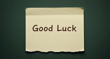 Good luck message on a piece of paper on a green background photo