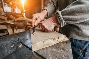 Carpenter Cutting Wood with a Bandsaw in a Rustic Workshop photo