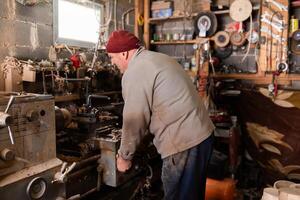 Elderly Craftsman Working in a Rustic Workshop photo