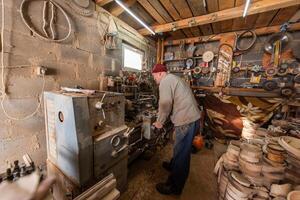 Elderly Craftsman Working in a Rustic Workshop photo
