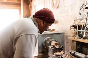 Elderly Craftsman Working in a Rustic Workshop photo