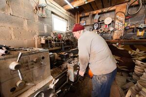 Elderly Craftsman Working in a Rustic Workshop photo