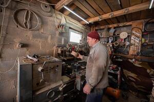 Elderly Craftsman Working in a Rustic Workshop photo
