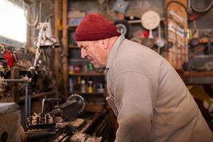 Elderly Craftsman Working in a Rustic Workshop photo