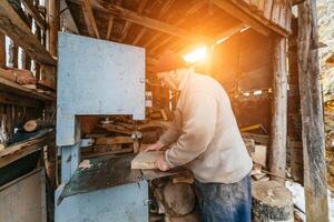 Carpenter Cutting Wood with a Bandsaw in a Rustic Workshop photo