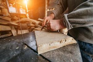 Carpenter Cutting Wood with a Bandsaw in a Rustic Workshop photo