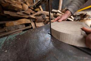 Carpenter Cutting Wood with a Bandsaw in a Rustic Workshop photo