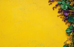 Mardi Gras background with beads and mask on yellow surface, copy space for text. photo