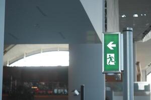 Emergency exit sign directing towards the left in a modern building photo