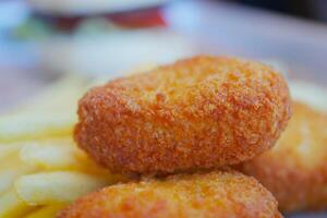 Crispy golden nuggets served with French fries in a casual setting photo