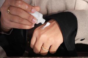 Application of moisturizer on hand in skincare routine photo