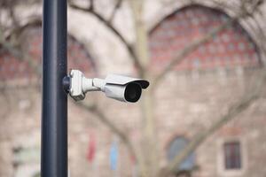 Security camera installed in urban area with historical background photo