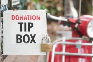 Donation tip box outside with a padlock in a public area photo