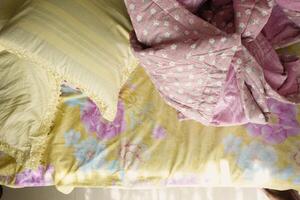 Cozy bed with colorful bedding and pillows in a bright room photo