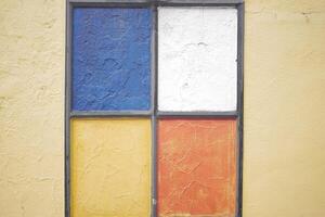 Colorful geometric window design on a textured wall in daylight photo