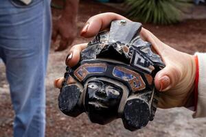 Tourist showing an obsidian handcraft to a group of visitors at the Teotihuacan archeological site. photo
