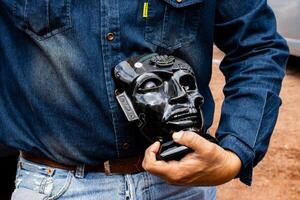 Guide showing an obsidian handcraft to a group of visitors at the Teotihuacan archeological site. photo