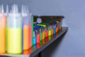 A row of colorful plastic containers on a shelf photo