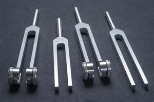 weighted and unweighted metal tuning forks used for tuning musical instruments, sound therapy or relaxation. photo