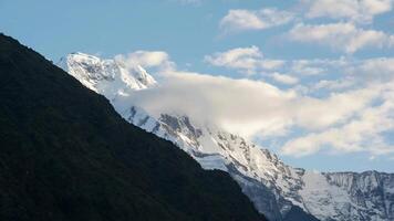 a mountain with snow on top and clouds in the sky video