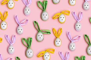 Handmade Easter eggs with color Bunny Ears on Pink Background, minimal Flat lay pattern, Easter holiday concept. Creative Spring festive layout. Top view Diy decorated wooden eggs, pastel colors photo