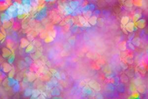 Defocused abstract floral bokeh background purple color, flare from lights, blurred bokeh of clover leaves shape as holiday texture. Colorful festive aesthetic textured lighting pattern photo