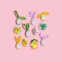 Handmade Easter eggs with Bunny Ears on Pink Background, minimal Flat lay pattern, Easter holiday concept. Creative Spring festive layout. Top view Diy decorated wooden eggs, pastel colors photo
