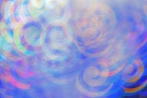Defocused abstract bokeh background blue lavender colored, flare from lights, color gradient, blurred figured bokeh as holiday texture. Glittering monochrome aesthetic lighting pattern photo