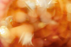 Defocused abstract bokeh background yellow golden color, flare from lights, monochrome photo, blurred round bokeh as holiday fon, celebration wallpaper. Glittering aesthetic textured photo pattern