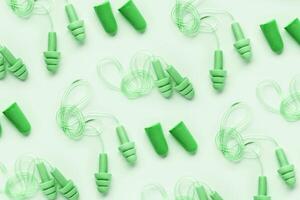 Color earplugs as minimal trend pattern, reusable silicone and rubber ear plug on cord against noise, protect hear, for swim, sleep, rest. Creative aesthetic flat lay, above view, pastel tones photo