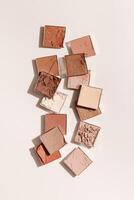 Beauty product neutral color eyeshadows for makeup, beige monochrome pattern on light background, flat lay with nude colors swatches eyeshade, cosmetic texture, beige color palette, top view pattern photo