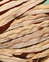 Natural autumn texture from narrow beige leaves with water drops. Beautiful autumnal botanical pattern, close up wet fall leaf of willow top view, aesthetic nature still life, macro photography photo