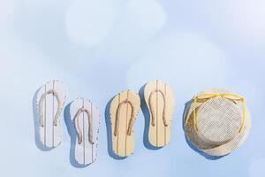 Trend Summer flat lay with beach accessories, sunglasses, sun hat, beach shoe sandals on blue background, copy space. Summer holiday or vacation concept, sunlight shadows, creative minimal style photo