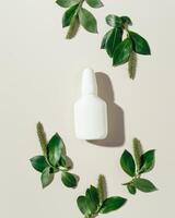 Seasonal spring allergies, fresh spring blooming branches tree with green new leaves and mock up white nasal spray bottle, beige background, top view trend pattern, Seasonal allergy concept photo
