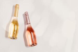 Top view sparkling wine, bottles of rose and white champagne with bokeh on beige, copy space. Festive alcohol drink, wedding party drink concept, beige pastel background, minimal style photo