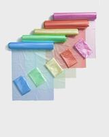 Set colored plastic bags in rolls as flat lay pattern. Colorful polyethylene packets on white. New clean disposable polythene packs.Waste reduction concept, zero waste, sustainable life style photo