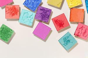 Cosmetics background, pattern of colorful eye shadow, top view swatches of makeup powder, close up eyeshadow palette. Set of bright various samples. Female cosmetics and beauty product photo