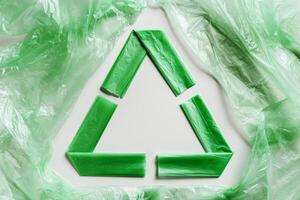 Recycling symbol made from green disposable plastic bags on white Waste reduction, Environmentally friendly, recycling concept. Pollution from Polyethylene packets, plastic bag free day photo
