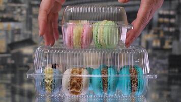 Flat lay colored macarons taken by hands one at a time video