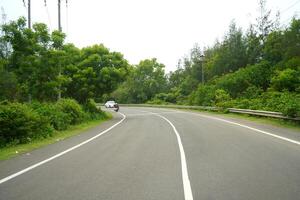 Clean and traffic free highway between green forest at odisha photo
