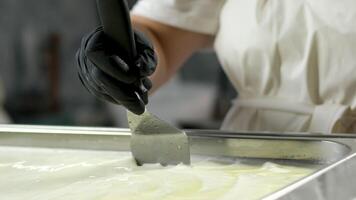 Step by step hands of skilled unrecognizable female factory worker in rubber gloves stretching elastic cheese mass production of mozzarella and cacacovala cheese making traditional cheese video
