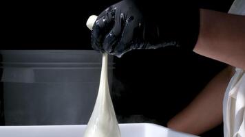 Step by step hands of skilled unrecognizable female factory worker in rubber gloves stretching elastic cheese mass production of mozzarella and cacacovala cheese making traditional cheese video
