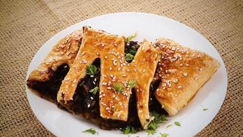 cooked puff pastries with mushroom filling and sesame seeds in a plate video
