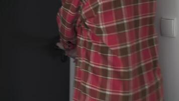 Person unlocking a black door with a key. Leaving home, safety, and controlled access video