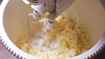Whipping smooth butter with sugar to create a creamy delight in slow motion video