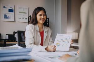 A woman is holding a chart and smiling at a table photo