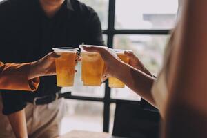 Three people toasting with drinks in front of a table photo